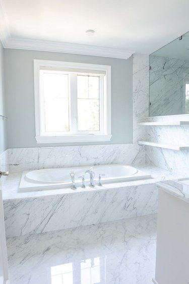 White bathtub in a white marble base.
