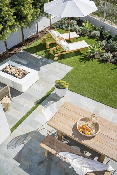 Clean and minimal outdoor space with lounge chairs and picnic bench