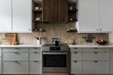 white kitchen color scheme with light gray and white cabinets and brown backsplash and hood