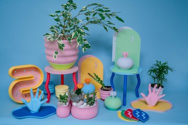 3D-printed designs on a blue background, colorful tables with squiggly legs, pink planters, and hand-shaped jewerly holders