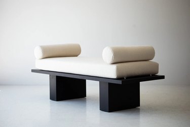 Daybed with a black base and a cream-colored bench