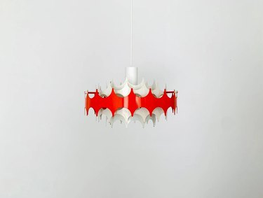 Red and white spiked lamp against a white background