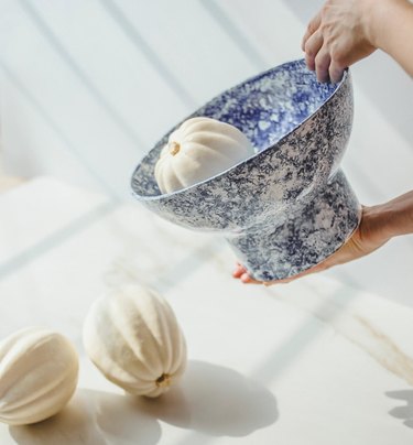 White and blue patterned bowl with a small, white pumpkin inside