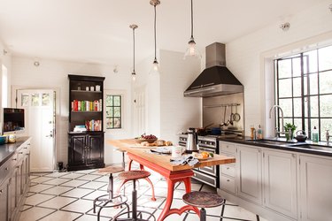 traditional kitchen with black and white grid tile and red industrial island