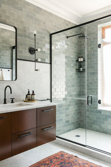 Light sage green subway tiles, dark wood vanity.