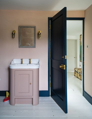 blush bathroom with industrial sconces and blue trim