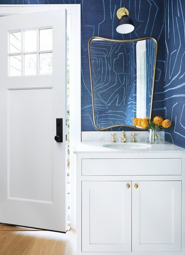 navy blue and white powder room with patterned wallpaper