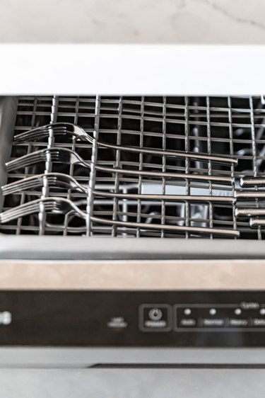 A dishwasher flap with forks placed on top
