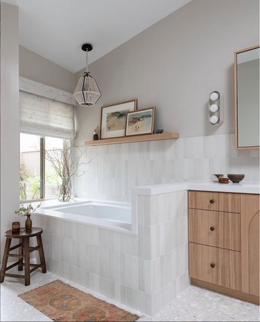 natural stone bathroom with multi-bulb vanity light and woven pendant