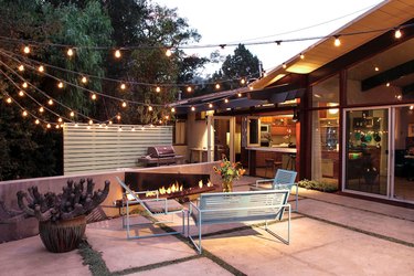 Outdoor space with string lights, fire pit, and backyard bar
