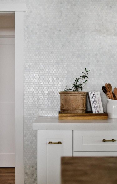 concrete countertop with tile backsplash and white cabinets