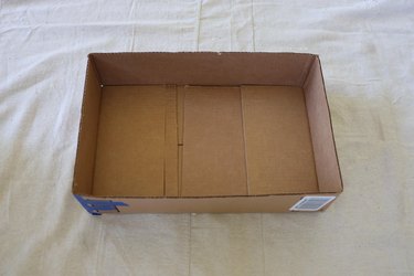 Cardboard box with sides cut down to two inches tall