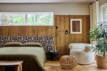 wood paneled bedroom with curvilinear chair in corner