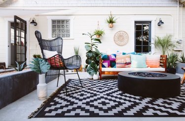 Patio with gas fire pit, chair, pillows, outdoor rug