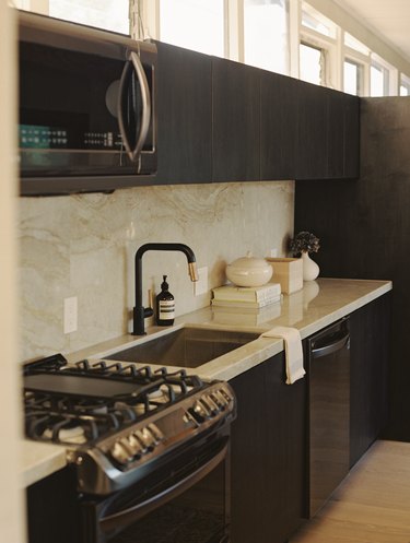 The sleek kitchen incorporates gold marble.