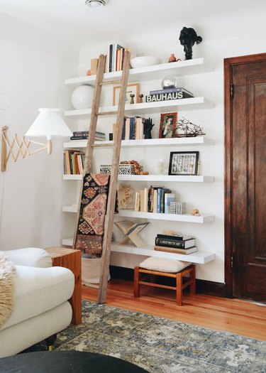 Neutral color palette library wall with floating shelves