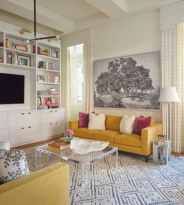 living room with yellow sofa and gray and white patterned area rug