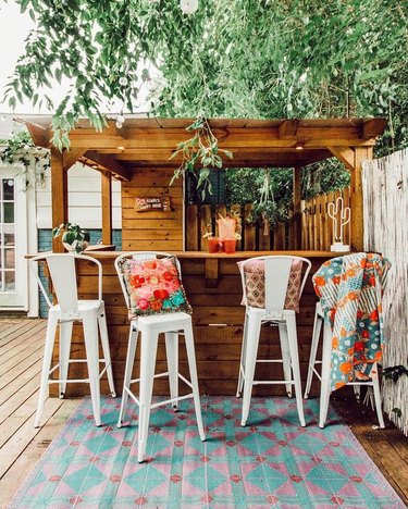 boho outdoor bar with throw pillows and rug