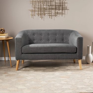 gray loveseat with wooden legs