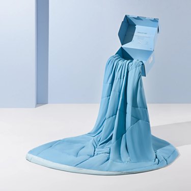 A blue comforter spilling out of a floating box