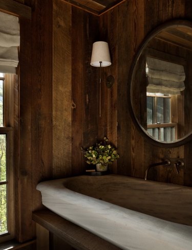 Wood paneled walls in bathroom with farmhouse style sink