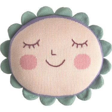 A light pink pillow featuring a face with a nose, mouth, and two eyes with four eyelashes each. The face is also blushing with two round pink circles on the cheeks. Around the edge, there is sage green scalloped trim.