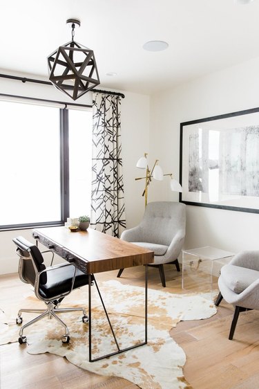 Modern Western office space with cowhide rug and modern light fixtures