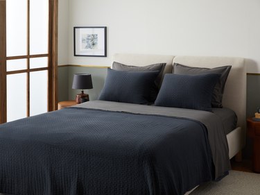 A bedroom with a navy bed