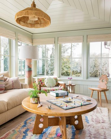 mint green living room with terra cotta lamp and many windows