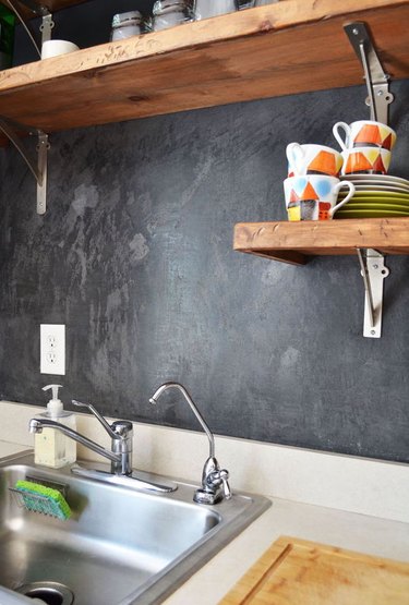 Dark black plastered walls in a small kitchen.