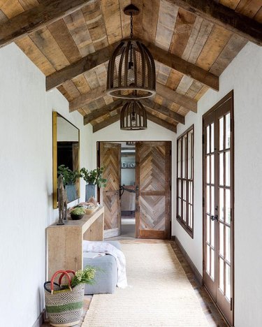 Expansive entryway with wood paneled ceilings, doors, and floors