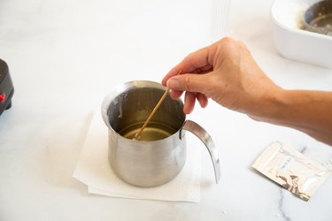 Stirring melted wax in pot