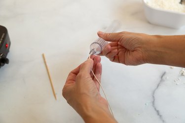 Adding wick to a candle mold