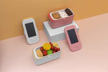 Solar-power lunch box with fruit, cookies, and phones