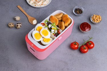 Solar-power lunch box with eggs, salad, and chicken nuggets