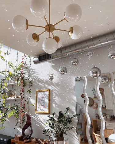 room with wavy mirrors and disco balls casting speckled light across walls