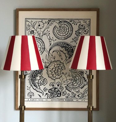 two circus-striped lampshades in front of wall art