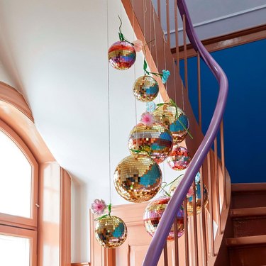 staircase with color-blocked banister and several disco balls