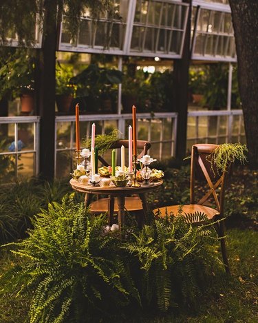 outdoor dining setup with wooden furniture and taper candles