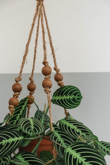 This boho hanging planter is made using a charger plate, rope, and beads.