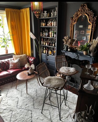 Home bar with high chairs and a liquor cabinet