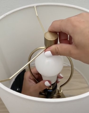 person screwing in rechargeable light bulb