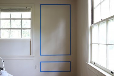 Painter's tape applied to wall to create the design of the wall molding placement