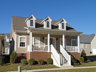 Beige siding with a red brick entryway on this house