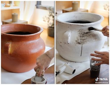 Brown planter on the left with a hand pouring baking soda into paint. Dirt is being painting on a white planter on the right.