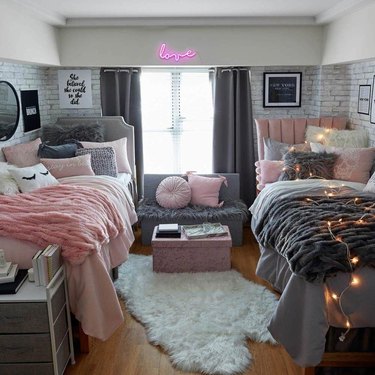 pink and gray dorm room with pink neon "love" sign