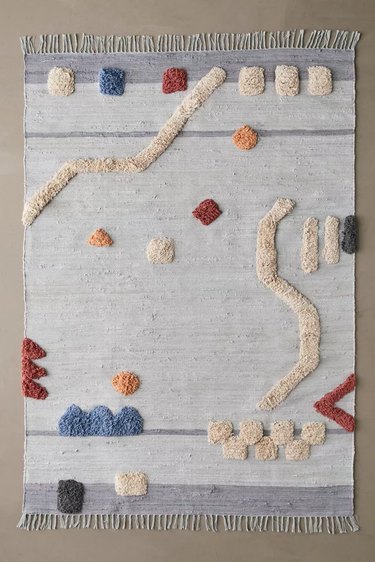 tufted area rug with fringes and abstract shapes