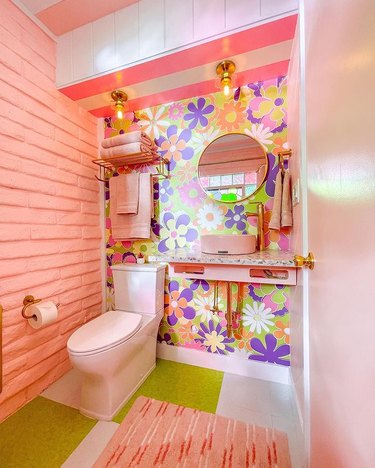 Colorful bathroom with floral wallpapers and blush wall