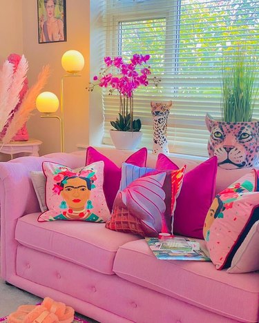 Colorful throw pillows on a pink couch