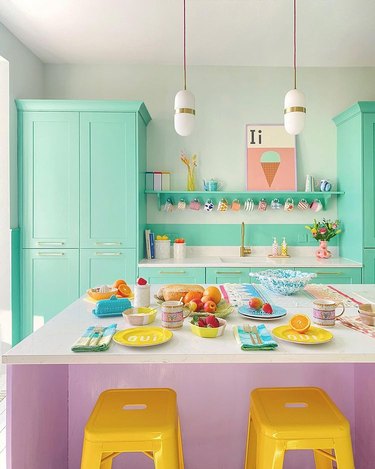 Dining room with mint green cabinets and yellow bar stools